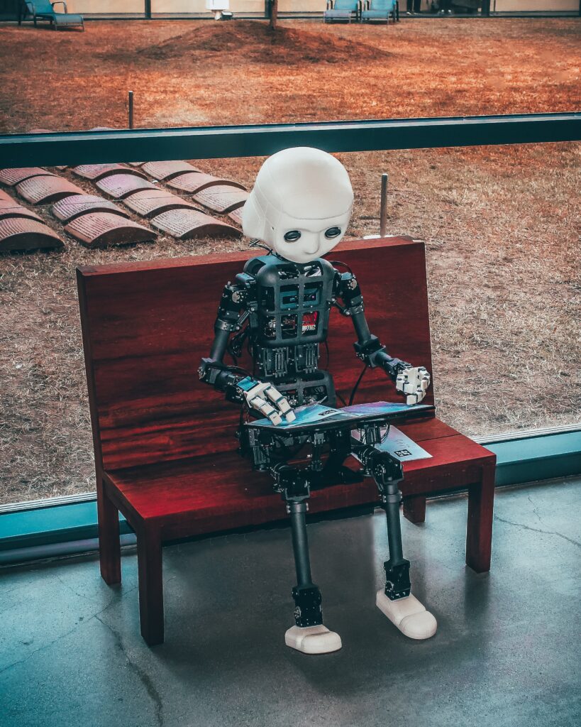 Robotti istuu penkillä ja katselee tabletin näyttöä.